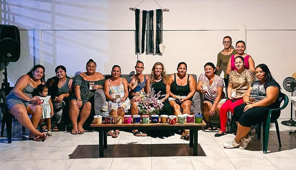 Un grupo de mujeres reunido en la sala de una casa, sentadas alrededor de una mesa baja durante un encuentro de Casas de Poder